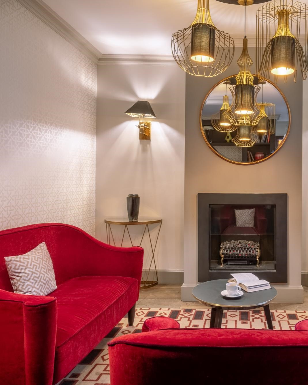 Sillones de terciopelo rojo y lamparas doradas en el Salón de Le Marquis 